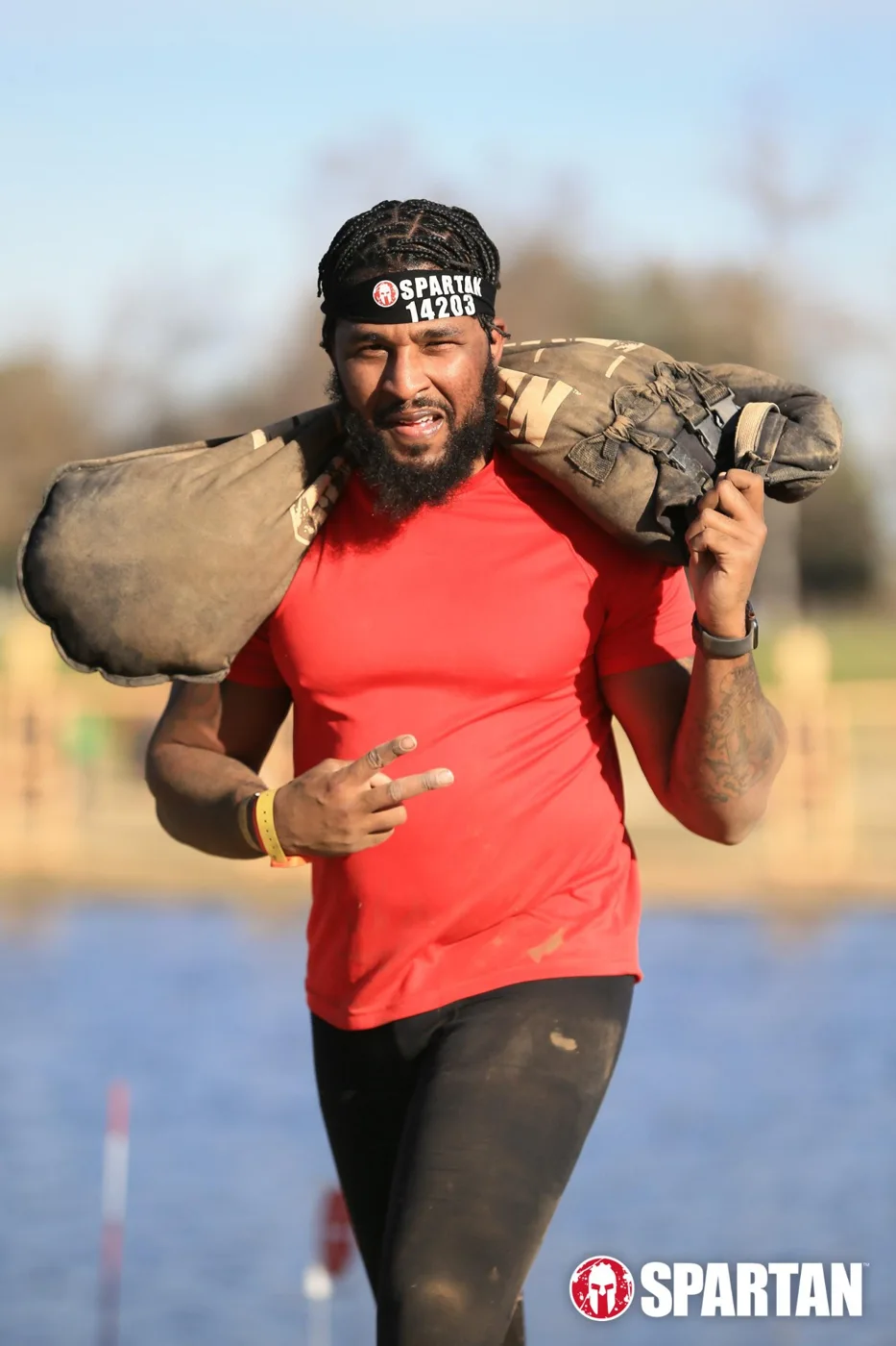 Sherman carrying a weighted bag at a Spartan race
